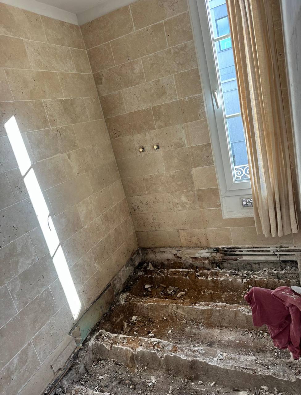 Salle de bain avant travaux — sol démoli, gravats